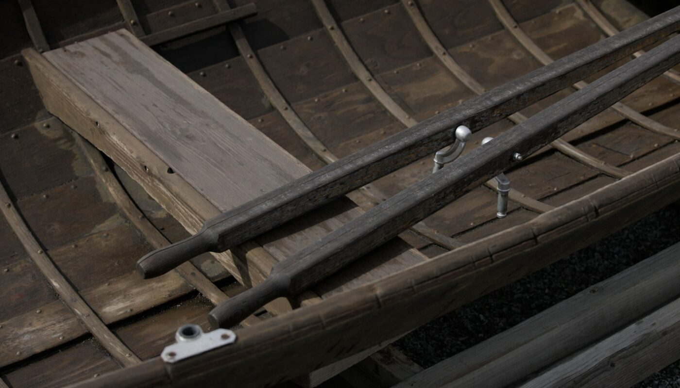 A wooden boat with a red flag on top of it